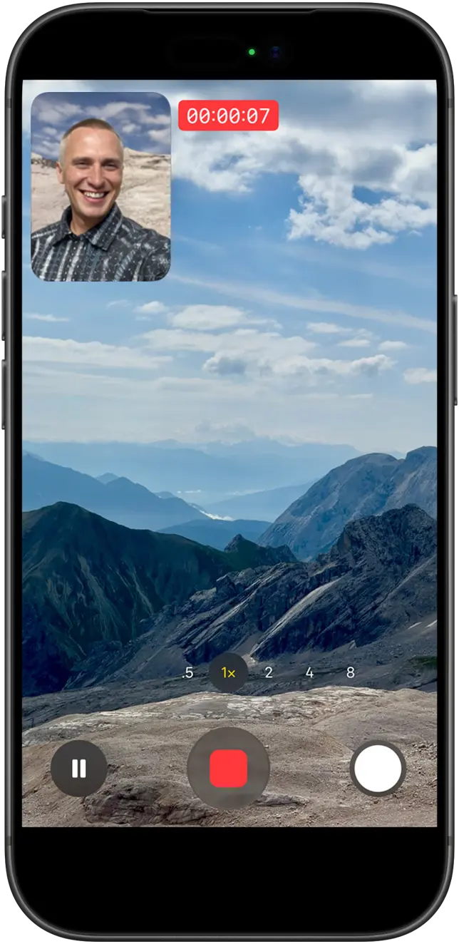 Человек демонстрирует видео с двойной съемкой: он снимает себя на фронтальную камеру и одновременно снимает живописные горы на заднюю
